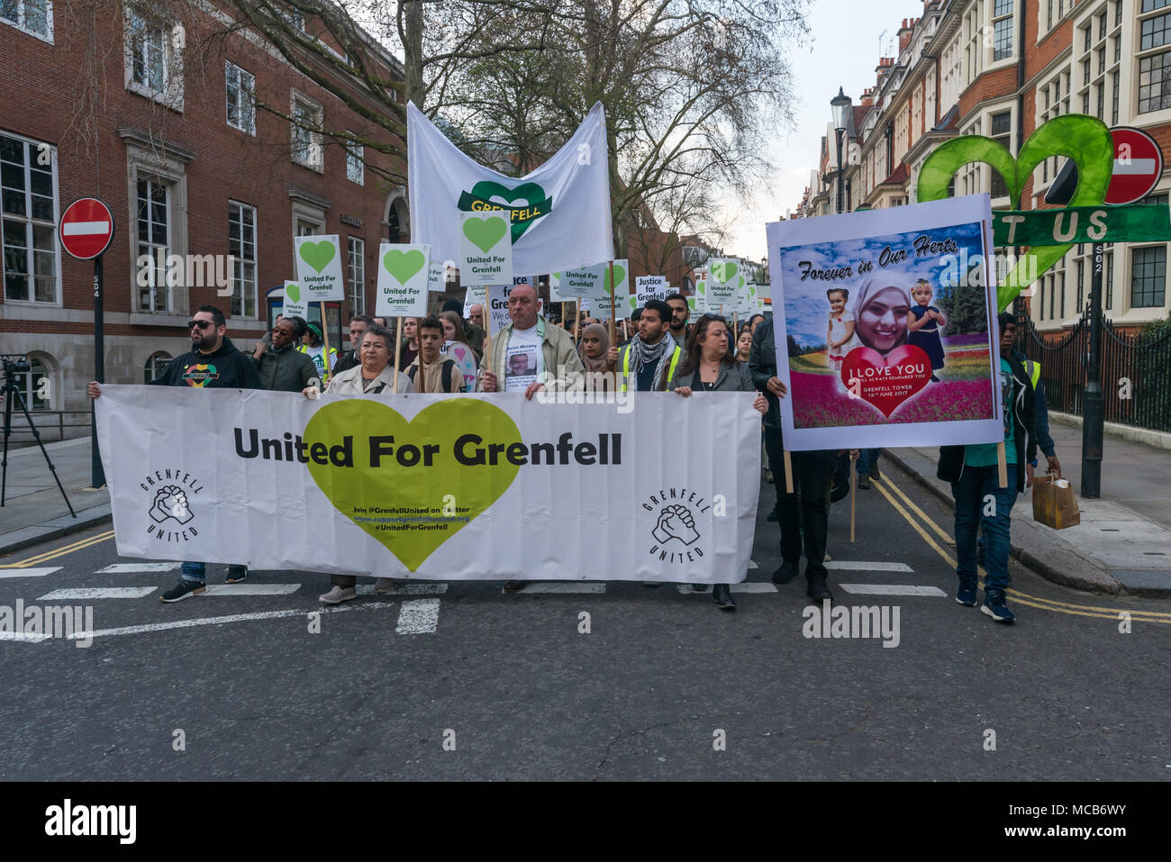 Londra, Regno Unito. Xiv Apr, 2018. Persone di cui molti hanno perso la famiglia e gli amici presso Grenfell prendere parte in una silenziosa a piedi dietro il regno per Grenfell banner marcatura dieci mesi dopo la catastrofe. Si sono incontrati a Kensington Town Hall per sottolineare che essi detengono di Kensington e di Chelsea Consiglio responsabile per la tragedia e per aver omesso di affrontare efficacemente con l' indomani, con molti superstiti non ancora rehoused correttamente. Credito: Peter Marshall / Alamy Live News Foto Stock