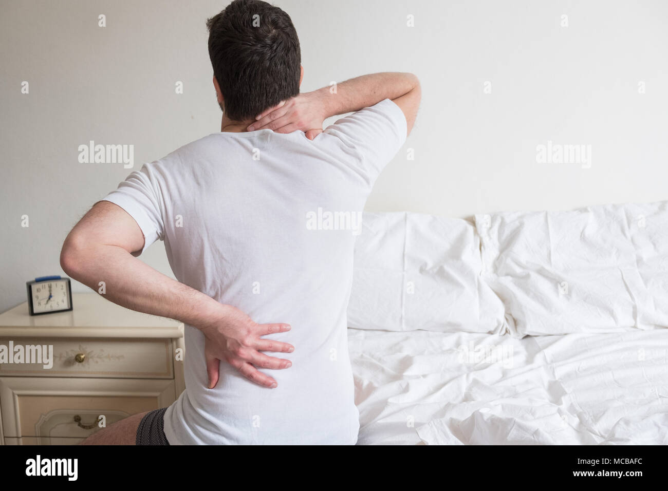 L uomo che soffre di mal di schiena a scendere dal letto Foto stock - Alamy