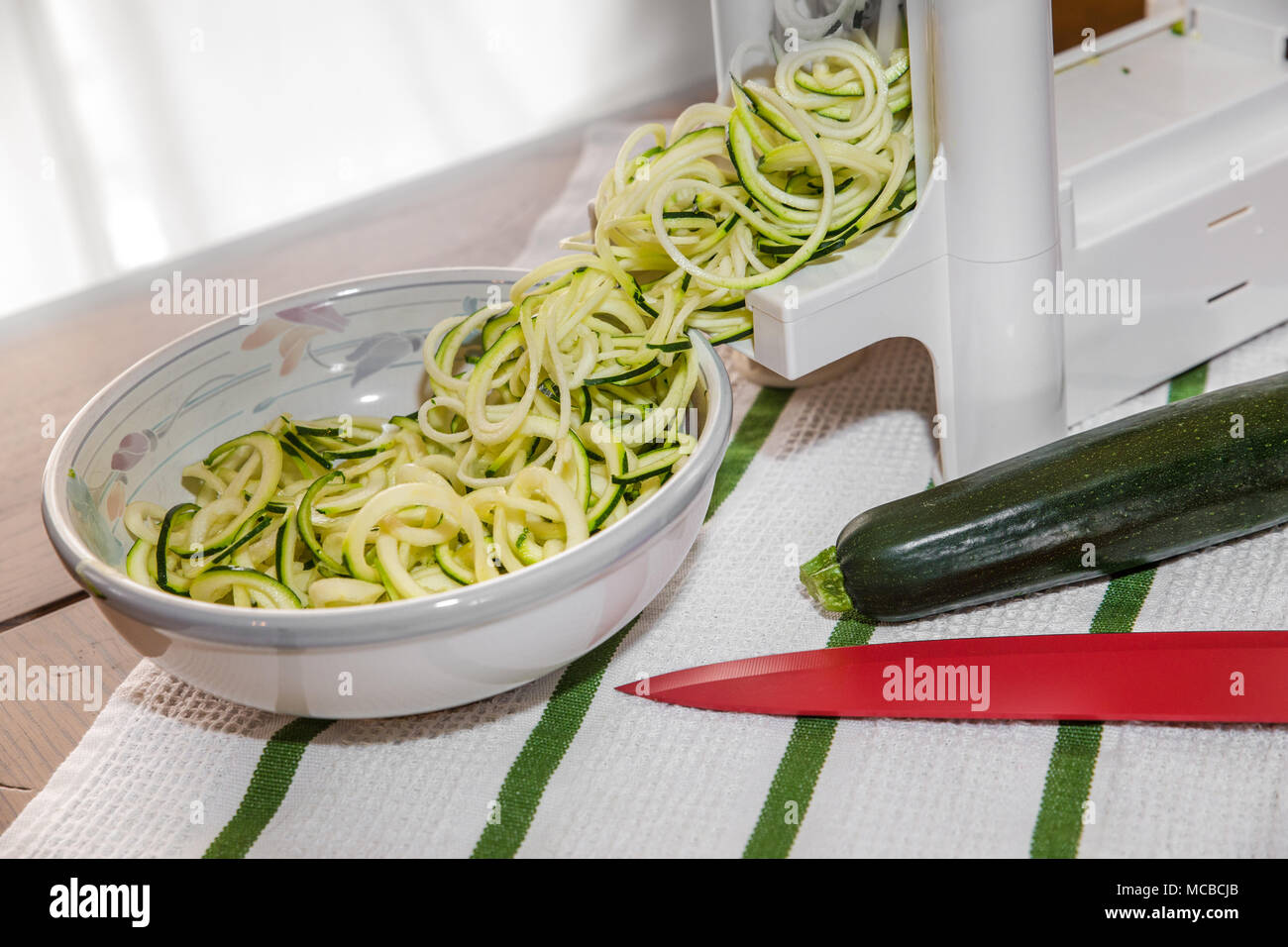 Zucchine a spirale noodles chiamato zoodles preparati in cucina spiralizer gadget Foto Stock