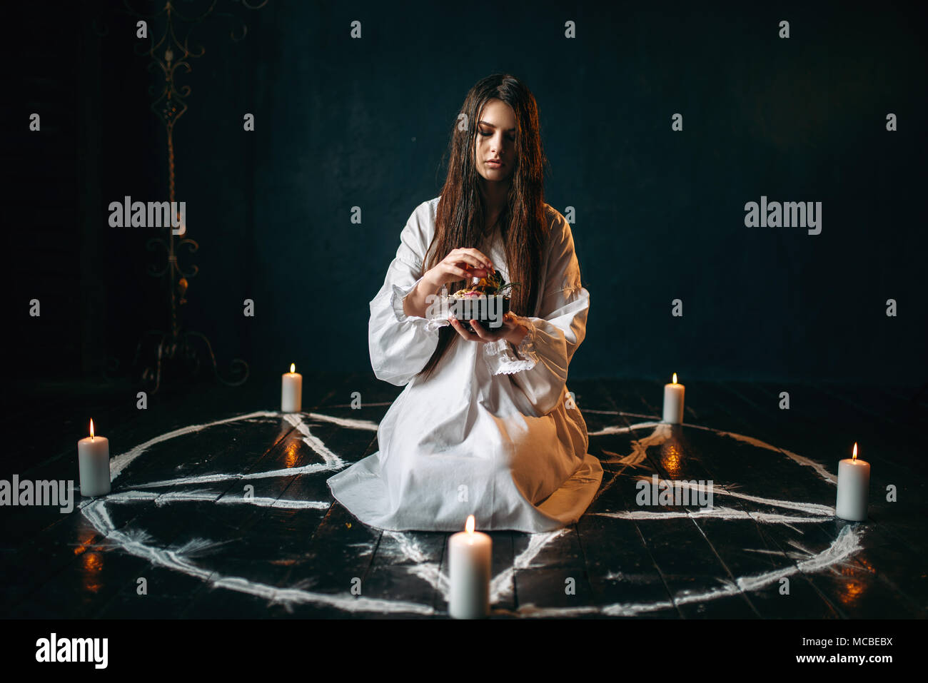 Donna produce un rituale di magia nera, occultismo Foto Stock