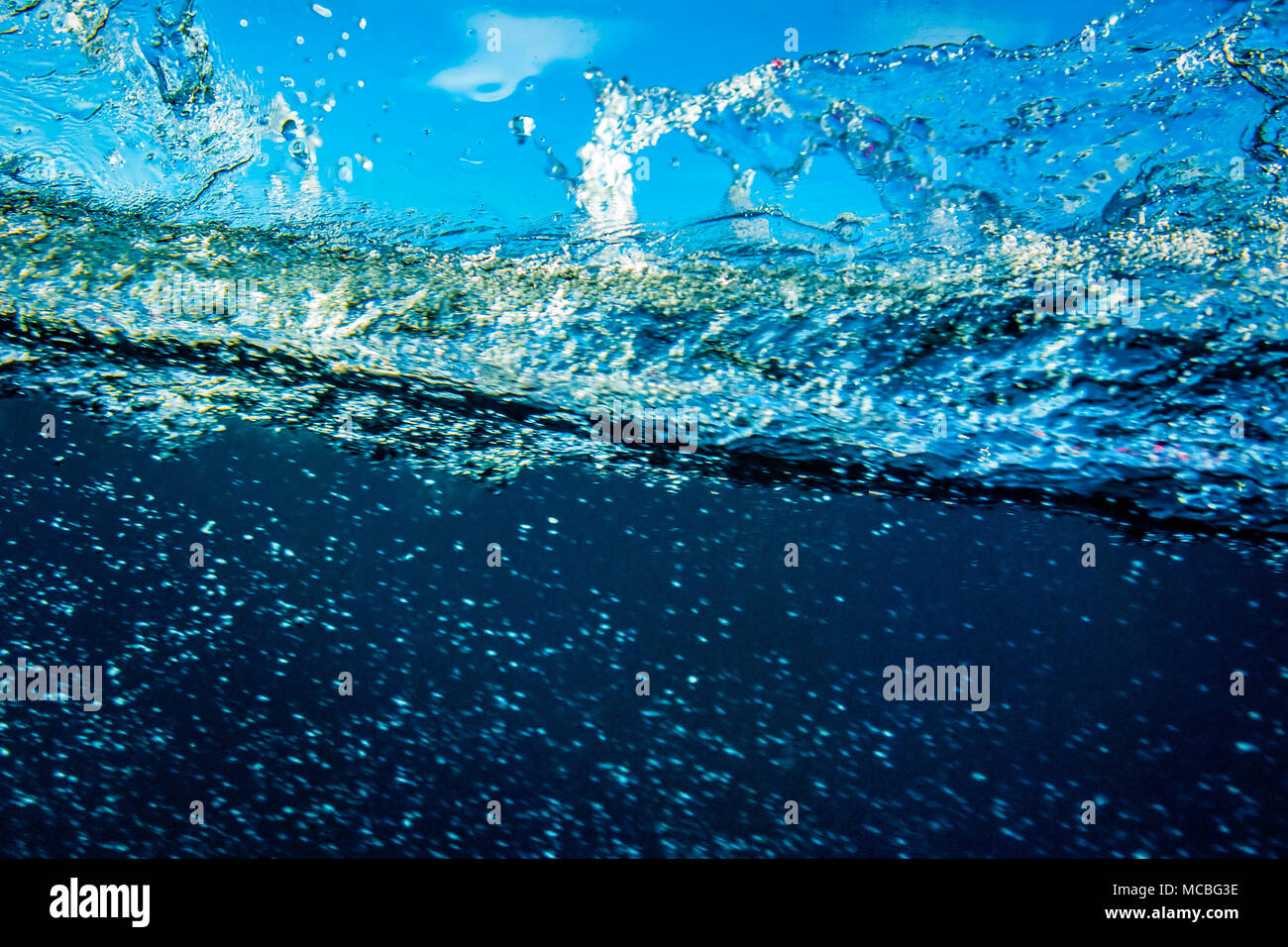 Colpo di subacquea ocean splash contro il cielo blu. Foto Stock