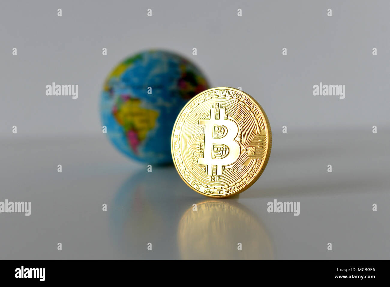 Bitcoin concetto. Economia mondiale concetto. Nuova moneta mondiale. Medaglia d'oro bitcoin e globo. Foto Stock