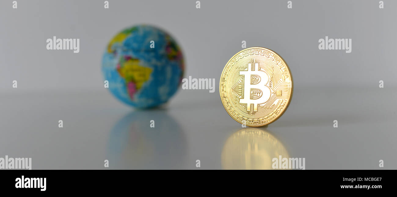 Bitcoin concetto. Economia mondiale concetto. Nuova moneta mondiale. Medaglia d'oro bitcoin e globo. Foto Stock