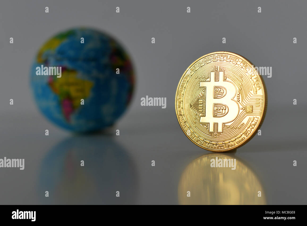 Bitcoin concetto. Economia mondiale concetto. Nuova moneta mondiale. Medaglia d'oro bitcoin e globo. Foto Stock