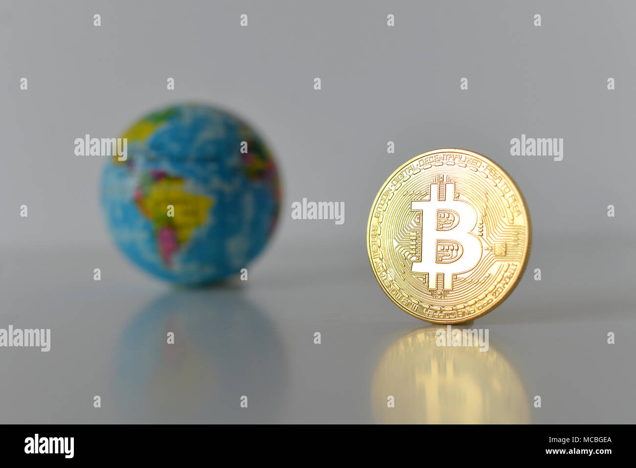 Bitcoin concetto. Economia mondiale concetto. Nuova moneta mondiale. Medaglia d'oro bitcoin e globo. Foto Stock