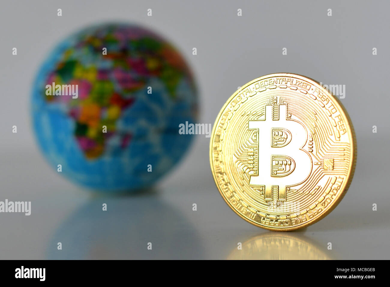 Bitcoin concetto. Economia mondiale concetto. Nuova moneta mondiale. Medaglia d'oro bitcoin e globo. Foto Stock