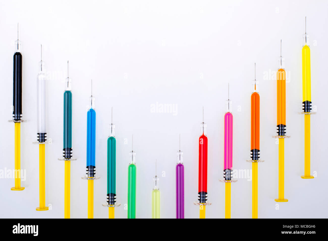 Più siringhe con aghi, riempito con vari colori di medicina/vaccini. Foto Stock