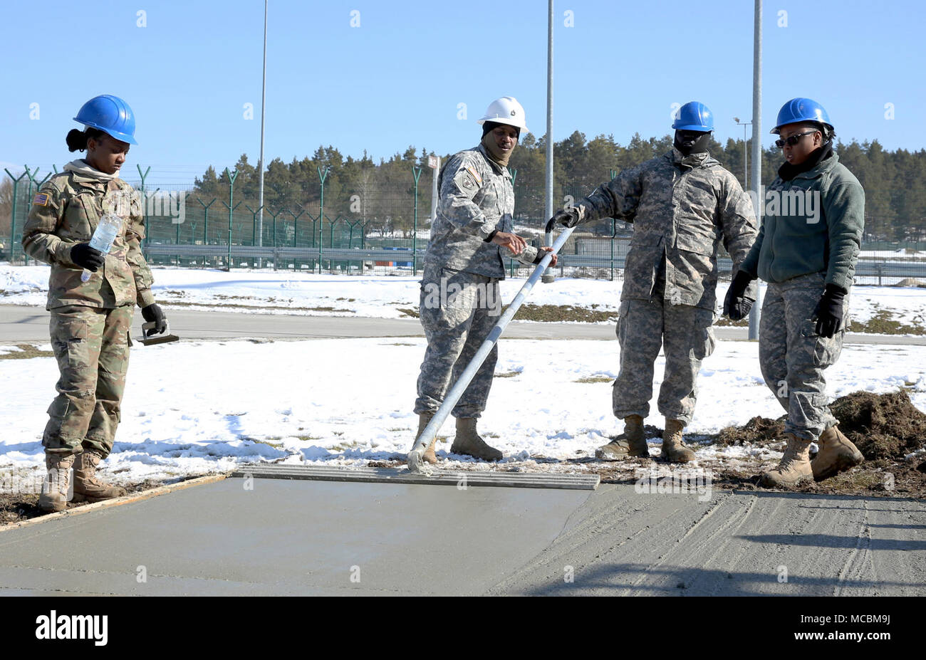 Un membro senior del tecnico 859th Company, Mississippi Esercito Nazionale Guardia, incarica altri soldati con opportune tecniche di lisciatura del calcestruzzo che assomiglierà presto finito di soletta in calcestruzzo. La bramma diventerà la fondazione in calcestruzzo sotto il gazebo. Questi soldati hanno trascorso la loro formazione annuale presso la multinazionale comune disponibilità del Centro di formazione Hohenfels Area, Hohenfels, Germania, la costruzione di diversi progetti di costruzione in marzo 11 - 31. Per molti dei giovani soldati questa è la prima volta che lavoro con concreta dopo la loro iniziale militare di abilità professionali formazione. Foto Stock