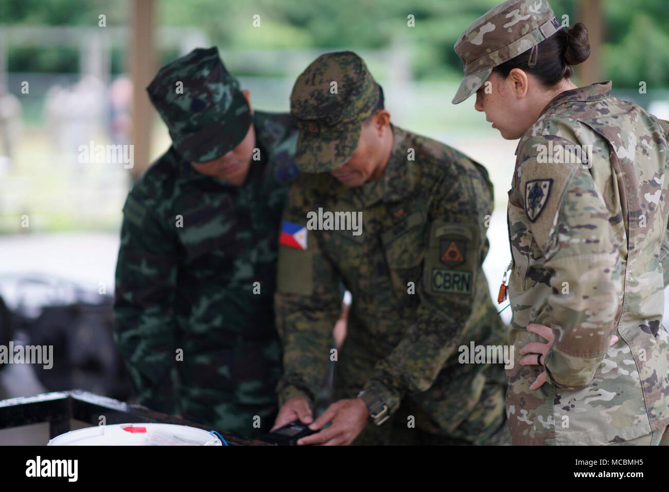1 Sgt. Sacha Moore con la difesa di riduzione della minaccia sovrintende Agenzia militari membri dalla Tailandia e Filippine come si pratica individuando campi radiologica da fonti di prova nel corso di una recente congiunta chimica radiologica biologiche nucleari (CBRN) scambio a Hawaii esercito Guardia Nazionale Regionale dell istituto di formazione in Waimanalo. Marzo 22, 2018. Foto Stock