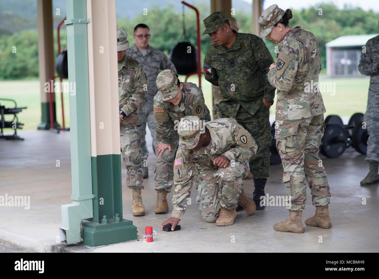 1 Sgt. Sacha Moore con la difesa di riduzione della minaccia sovrintende Agenzia militari membri provenienti dal Giappone, la Tailandia e le Filippine, lungo con servizio attivo i soldati della XXV divisione di fanteria come si pratica individuando campi radiologica da fonti di prova nel corso di una recente congiunta chimica radiologica biologiche nucleari (CBRN) scambio a Hawaii esercito Guardia Nazionale Regionale dell istituto di formazione in Waimanalo. Marzo 22, 2018. Foto Stock