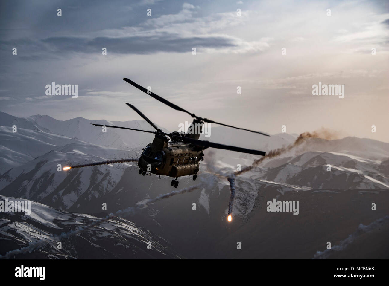 Un U.S. Esercito Task Force Brawler CH-47F Chinook rilascia flares durante la conduzione di un esercizio di formazione con un angelo custode team assegnato all'ottantatreesimo Expeditionary squadrone di salvataggio a Bagram Airfield, Afghanistan, Marzo 26, 2018. L'esercito degli equipaggi e Air Force Angelo Custode squadre condotta l'esercizio per costruire il lavoro di squadra e di procedure che forniscono personale comune la capacità di recupero, aiutando la consegna di airpower DECISIVO PER GLI STATI UNITI Il comando centrale. Foto Stock