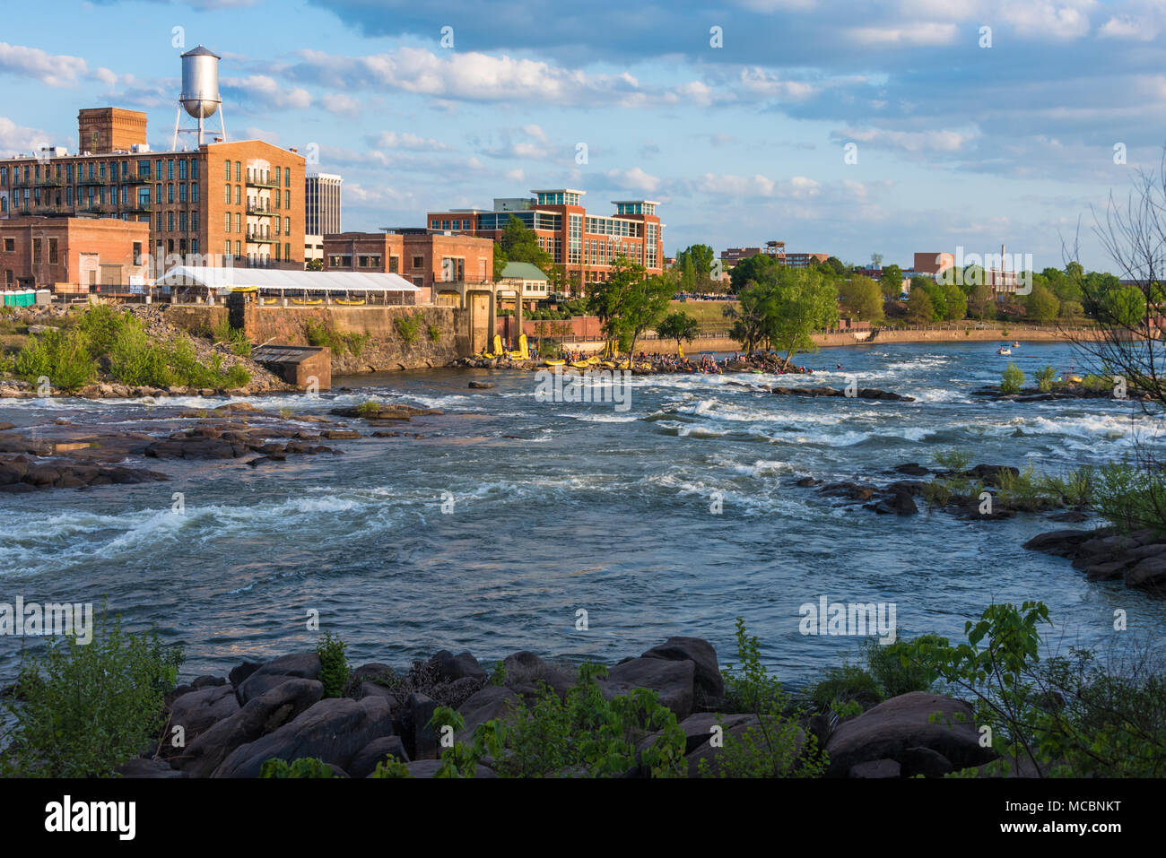 Columbus, Georgia skyline lungo il fiume Chattahoochee waterfront al tramonto durante gli Stati Uniti Kayak Freestyle campionato nazionale. Foto Stock