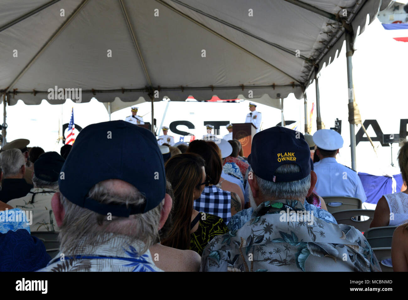 Attuali ed ex Guardacoste Sherman il suo equipaggio, i familiari e gli amici ascoltare Capt. Steven Whittrock, Sherman il comandante, come egli affronta i membri del pubblico durante la Sherman della cerimonia di smantellamento a Honolulu, Marzo 29, 2018. Nuove attività come la sicurezza nazionale Taglierine e Offshore Patrol e TAGLIERINE FRESE Fast-Response sostituirà l'invecchiamento della flotta di 378-piede alta Endurance taglierine come Sherman che serviva meritoriously in guardia costiera per quasi cinquant'anni. Foto Stock