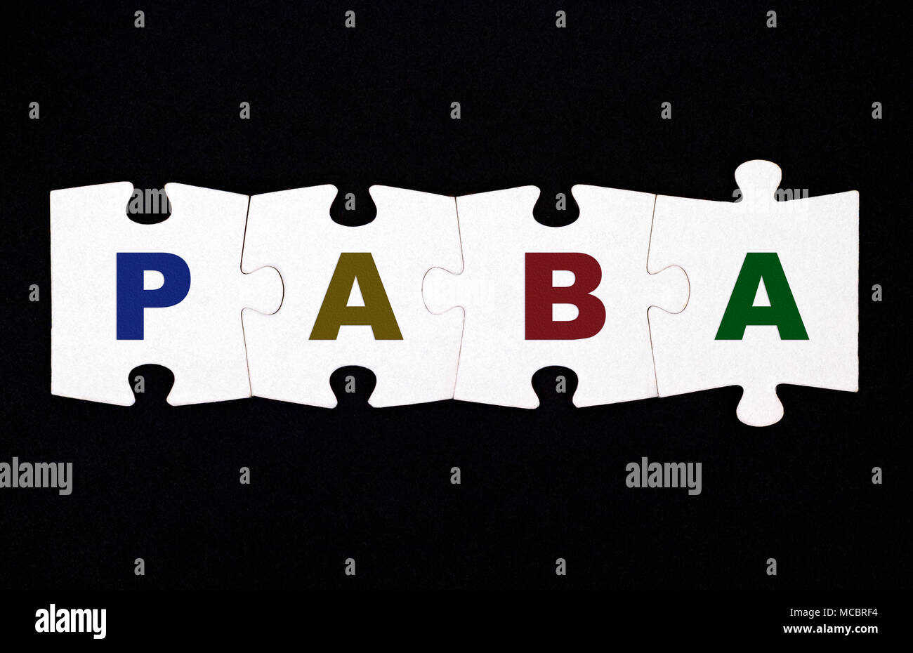Quattro pezzi di un puzzle con lettere PABA sono collegati insieme su sfondo nero Foto Stock