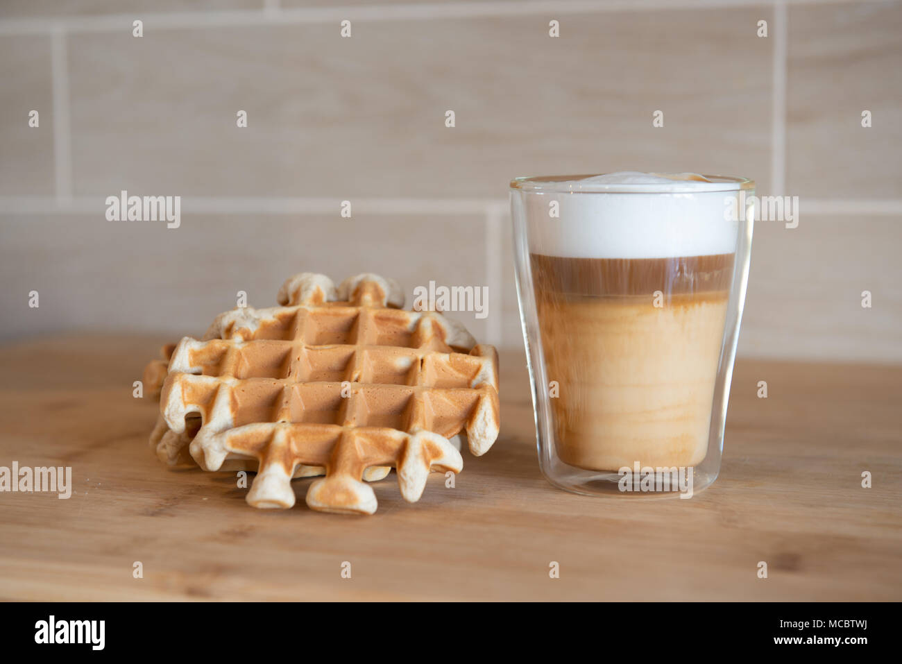 Le coppe di vetro di caffè multistrato con mini stroopwafel, syrupwaffles cookie su sfondo grigio chiaro con copia spazio. waffle cookies Foto Stock