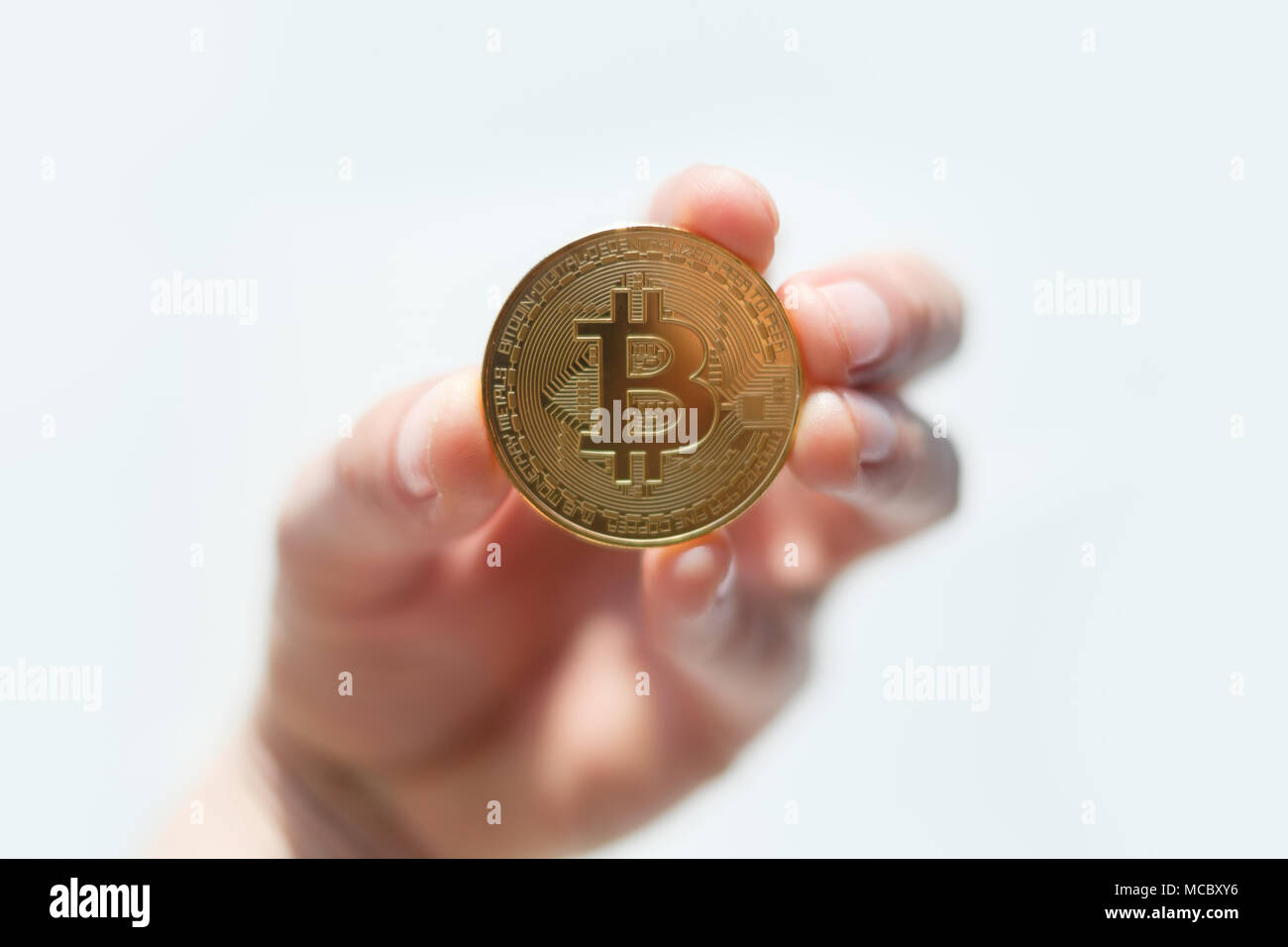 Golden bitcoin coin in man mano closeup Foto Stock