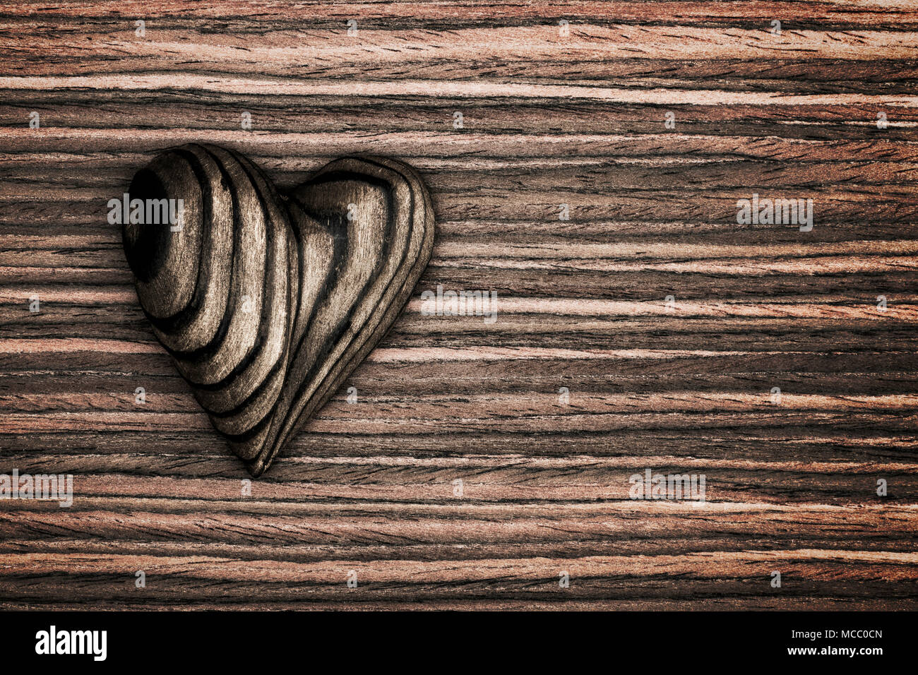 Strisce di legno cuore collocato su un vintage grunge Sfondo legno. Foto Stock