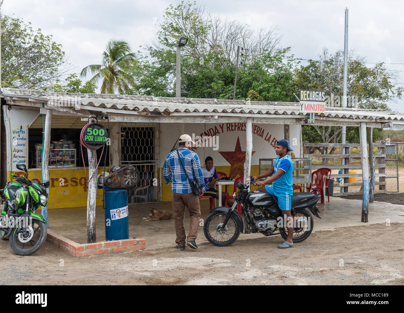 Un uomo sulla moto di parlare agli altri in una zona rurale petro station. La Colombia, Sud America. Foto Stock