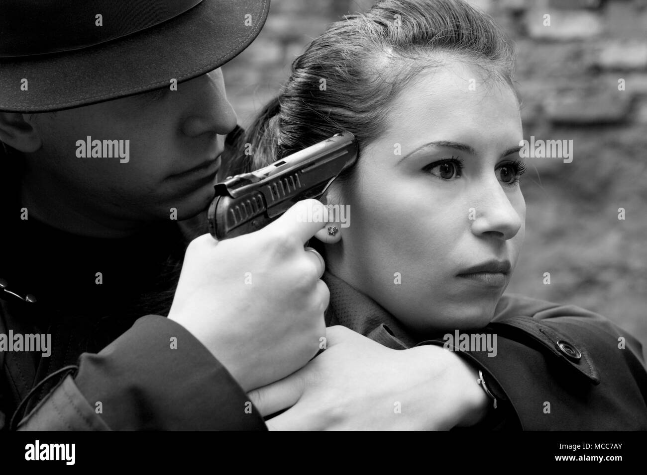 Ritratto monocromatica dell'uomo minaccia la donna con una pistola Foto Stock