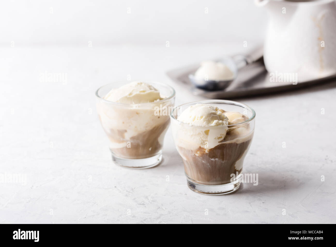 Affogato in casa, tradizionale dolce italiano con gelato alla vaniglia e caffè espresso su di colore grigio chiaro nella tabella Foto Stock
