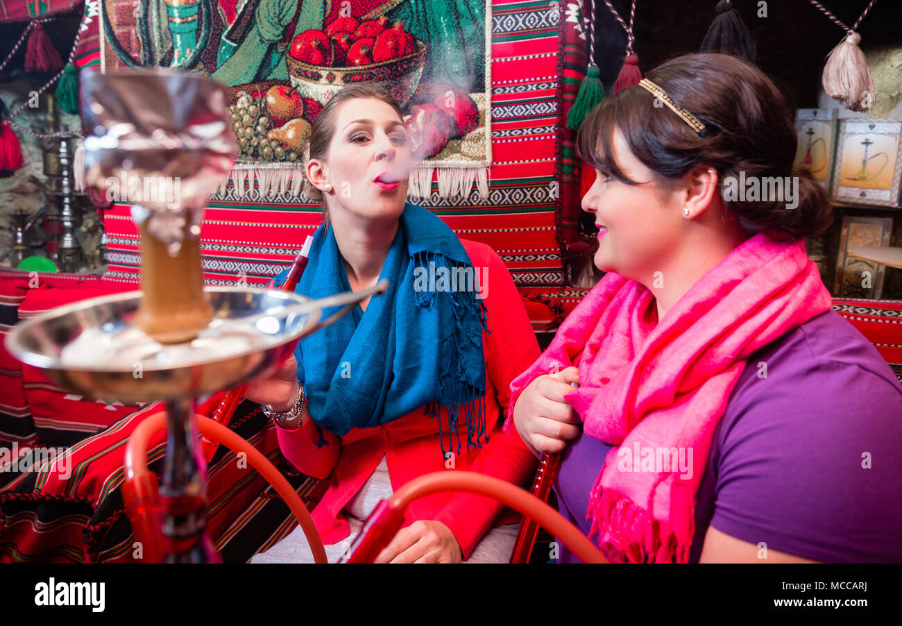 Le donne godono hookah o shisha in oriental cafe Foto Stock