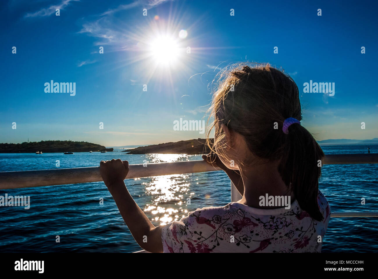 Bambina di guardare il tramonto dalla barca. Croazia, isola di Rab. Foto Stock