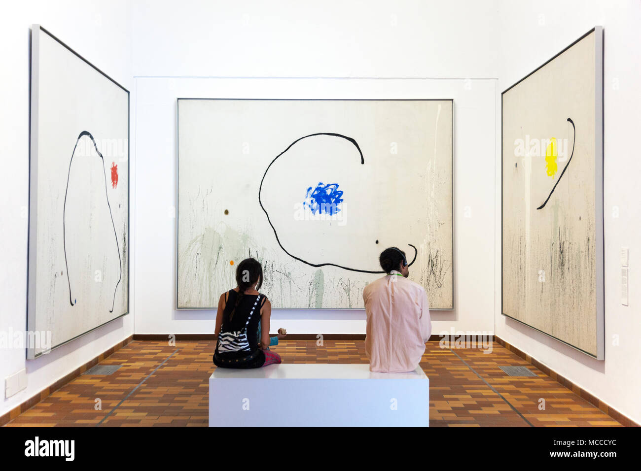 Due persone all interno di un museo guardando dipinti alla Fondazione Joan Miró di Barcellona, Spagna '(la speranza di un condannato' serie da Miro) Foto Stock