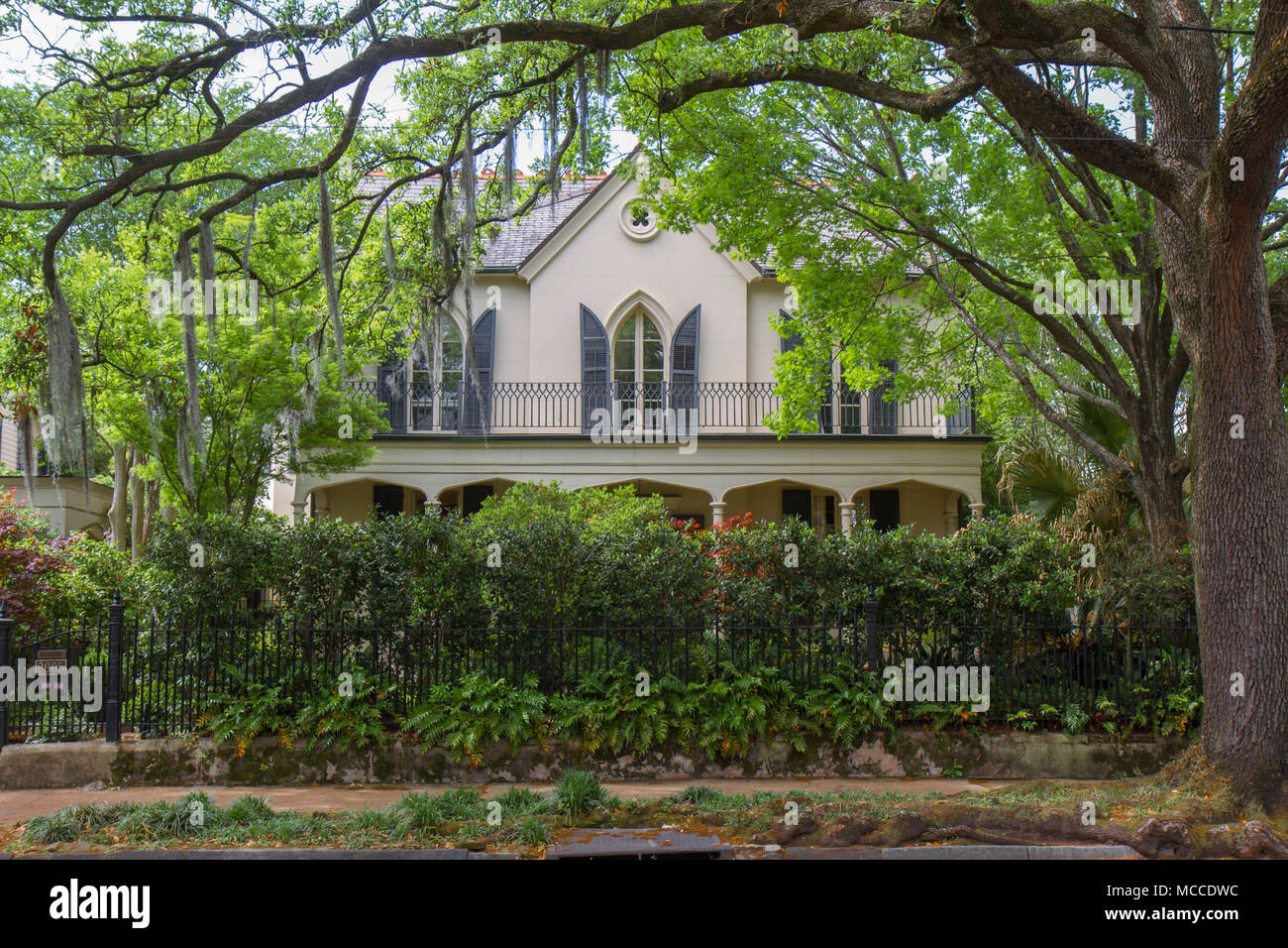 Mansion nel Garden District di New Orleans, in Louisiana, Stati Uniti d'America. Storia superiore le finestre sono incorniciate da rami del sud Live Oak tree con muschio Spagnolo Foto Stock