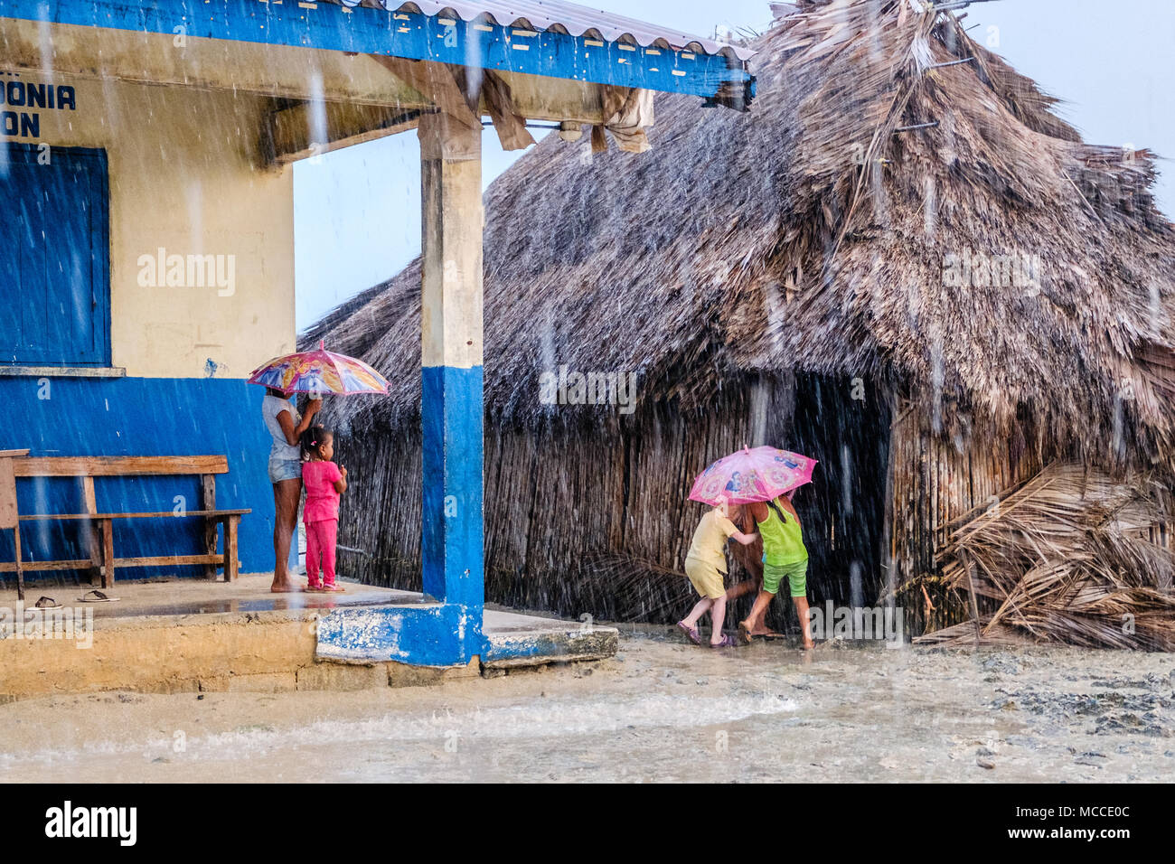 Guna Yala, Panama - marzo 2018: gruppo di giovani bambini con ombrello in caso di pioggia sulla strada di un villaggio Kuna, isole San Blas Foto Stock