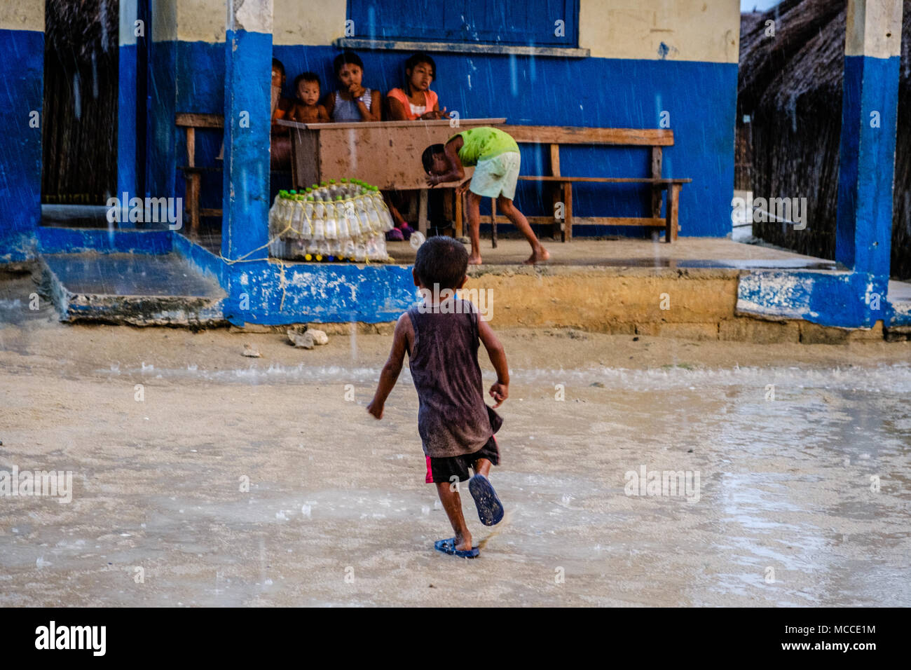 Guna Yala, Panama - marzo 2018: un gruppo di bambini che giocano sulla strada in un villaggio Kuna in un giorno di pioggia Foto Stock