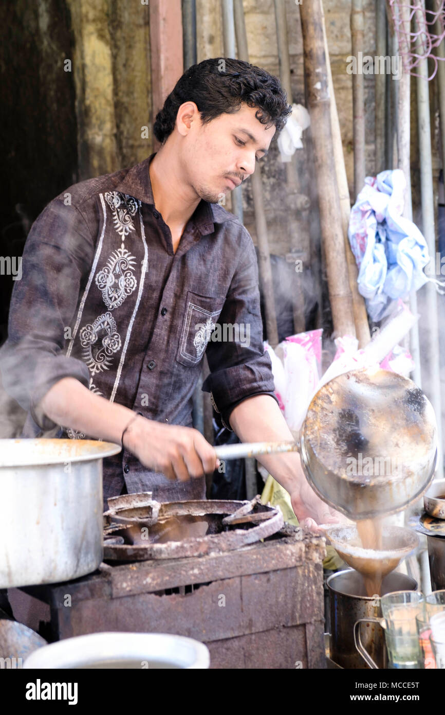 Un uomo versando masala chai (tè indiano) a una pressione di stallo di tè su Nagdevi street vicino mercato Crawford, Mumbai Foto Stock