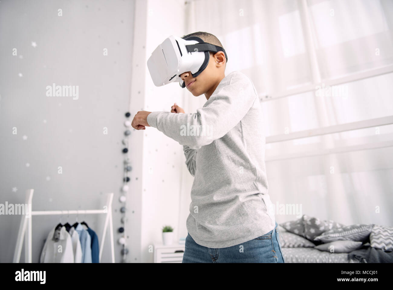 Focalizzato attento ragazzo combattimenti in VR Foto Stock