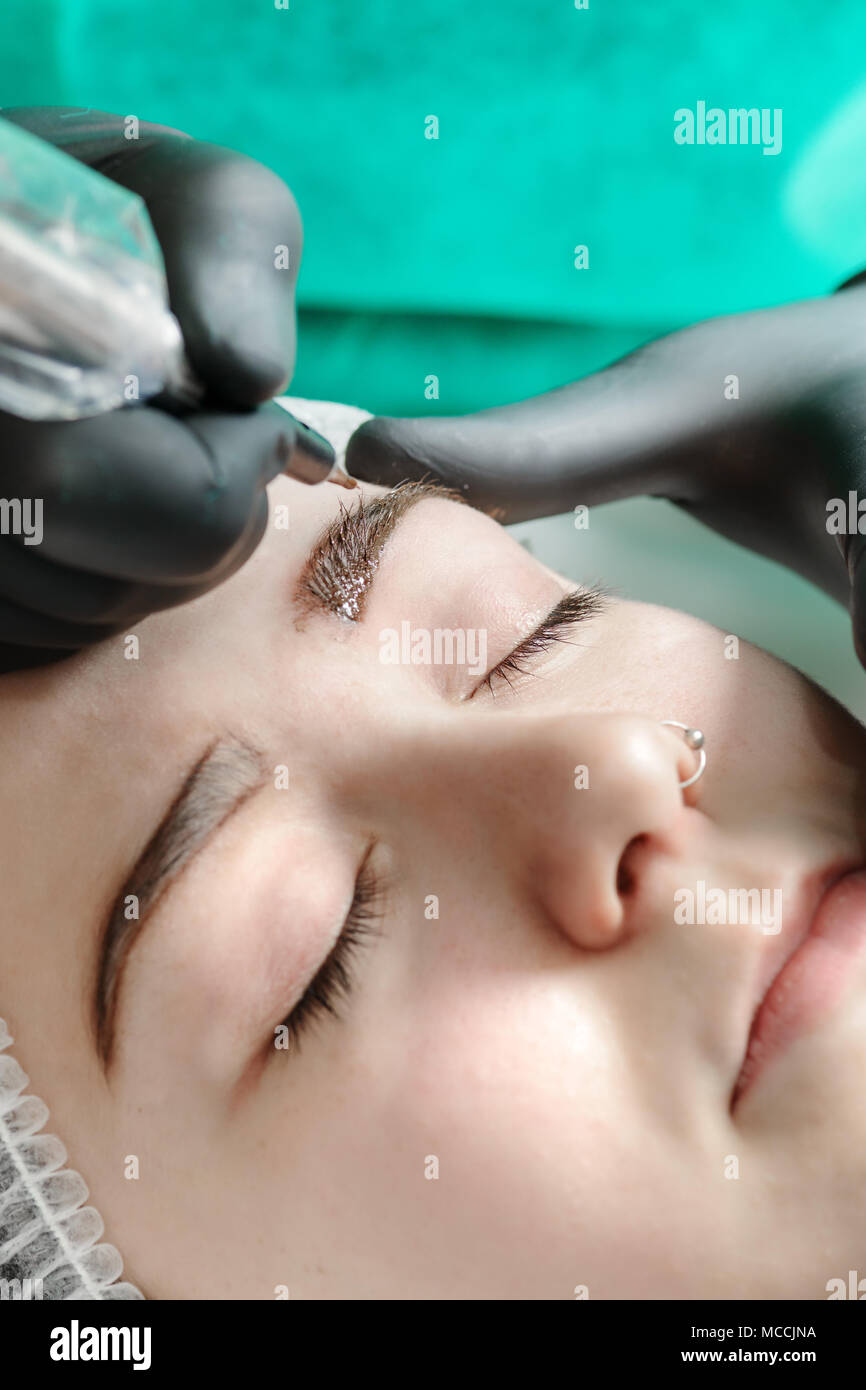 Trucco Permanente. Il tatuaggio permanente delle sopracciglia. Cosmetologo applicare trucco permanente sulle sopracciglia- tatuaggio sopracciglia Foto Stock