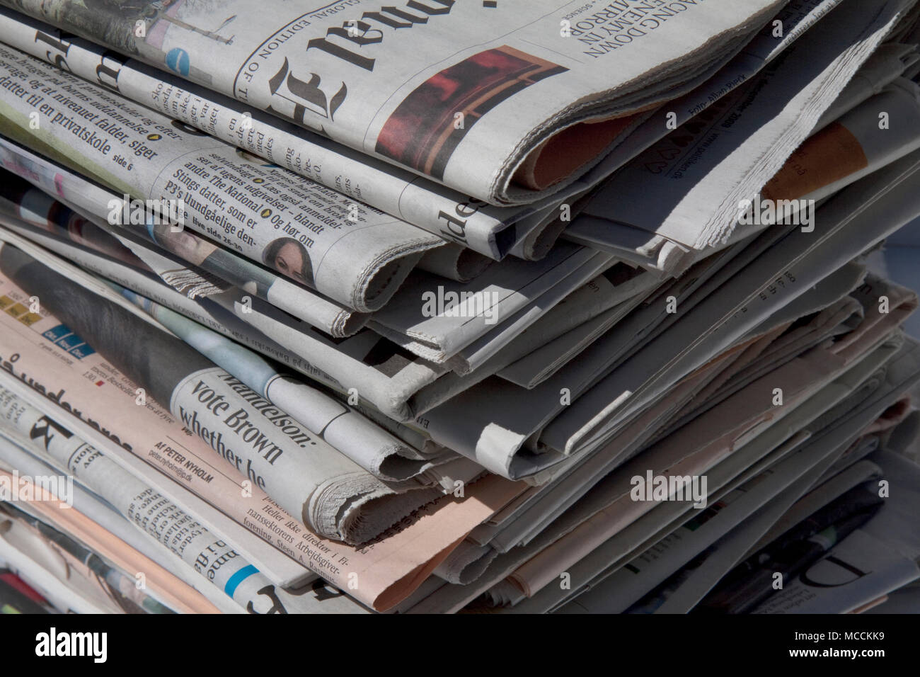 Mondo quotidiani di raccolta in un mucchio di notizie e informazioni di lettura. Foto Stock