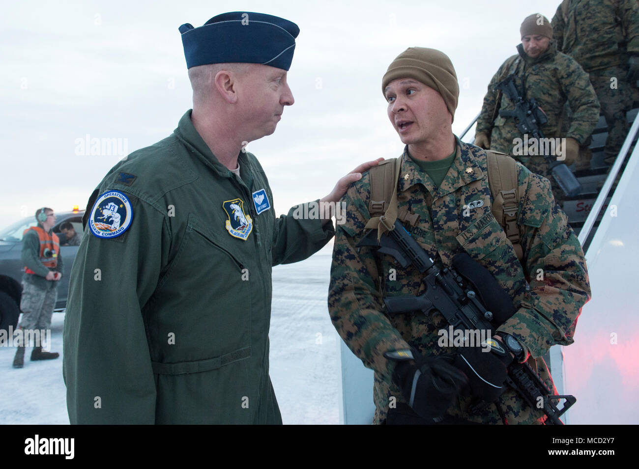 Air Force Col. Mark Schmidt, direttore delle operazioni di comando in Alaska, saluta la visita U.S. Marines con lo scopo speciale Marine-Air-Massa Force-Arctic attività di bordo 18 come essi arrivano a base comune Elmendorf-Richardson, Alaska, Feb 13, 2018. I marines sono a JBER a sostegno di Arctic Edge 2018, una biennale su grande scala, joint-esercizio che prepara e prove il militare degli Stati Uniti è la sua capacità di operare tatticamente nel freddo estremo-Condizioni meteorologiche rilevate in ambienti artici. Sotto l'autorità del North American Aerospace Defense e U.S. Comando Nord, più di 1500 particip Foto Stock