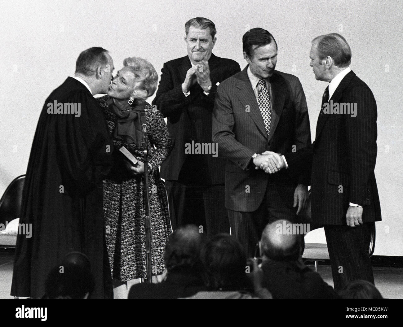 Il Presidente degli Stati Uniti Gerald Ford scuote le mani con George H.W. Bush, che ha prestato giuramento come direttore della Central Intelligence Agency (CIA) presso l'agenzia ha sede a Langley, Virginia, il 30 gennaio 1976. Da sinistra a destra: associare la giustizia degli Stati Uniti La Corte suprema Potter Stewart; Barbara Bush; Vernon Walters, Vice Direttore della CIA; Direttore Bush; il Presidente Ford. Credito: Barry Soorenko/CNP /MediaPunch Foto Stock