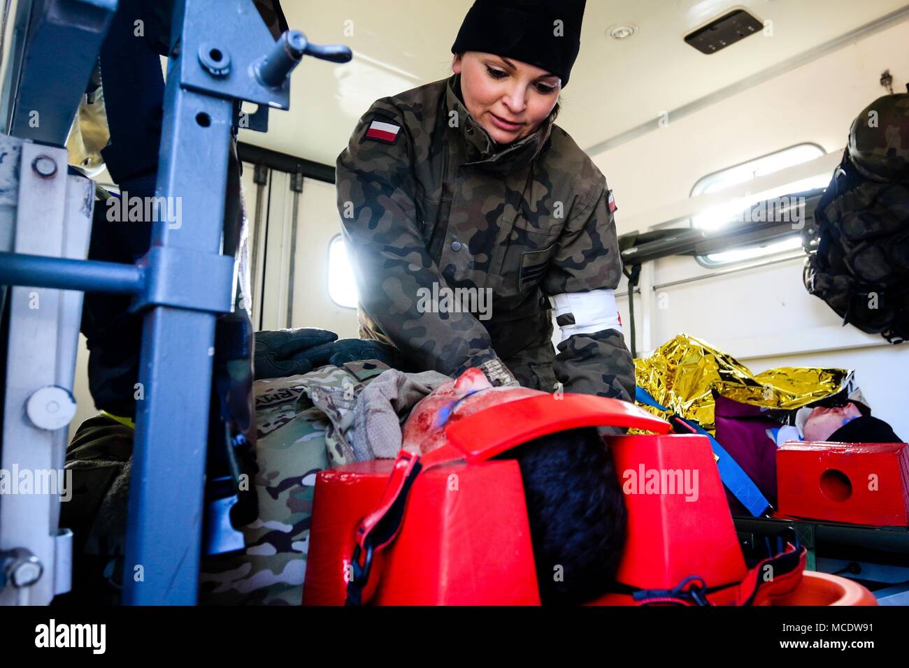 Un soldato polacco con l'undicesima Armored Cavalry Division (superiore), fissa U.S. Army Spc. Christopher Galloza-Candelaria, un Aguada, Puerto Rico nativo e una unità di alimentazione con uno specialista della ottantaduesima brigata battaglione ingegnere, 2° Brigata corazzate contro la squadra, 1a divisione di fanteria, durante una simulazione di esercizio di gestione delle crisi in Zagan, Polonia nel febbraio 26, 2018. La multinazionale della formazione è stato fatto per aumentare l'interoperabilità con il polacco prima i soccorritori e forze armate mentre a sostegno di Atlantic risolvere. (U.S. Esercito foto di Spc. Hubert D. Delany III / 22nd Mobile degli affari pubblici distacco) Foto Stock