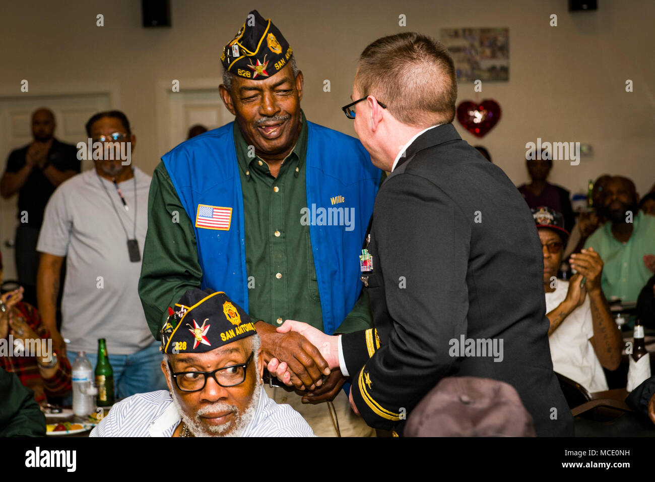 180220-N-EO381-0159 SAN ANTONIO (feb. 20, 2018) Tenente j.g. Mack Jamieson fornisce un pin per un American Legion Fred Brock Post n. 828 veterano di guerra di Vietnam come parte di San Antonio Navy settimana. San Antonio è una delle città selezionate per ospitare una marina 2018 settimana Una settimana dedicata al sollevamento U.S. Navy consapevolezza attraverso irradiazione locale, i servizi alla comunità e mostre. (U.S. Foto di Marina di Massa lo specialista di comunicazione di terza classe Casey J. Hopkins/rilasciato) Foto Stock