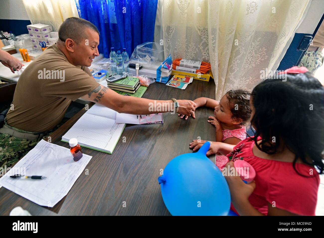 180409-N-VK873-0314 PUERTO BARRIOS, Guatemala (9 aprile 2018) Lt. Sean Valdez, di Modesto, California, fornisce adesivi per bambini a Izabal complesso sportivo sito medico in Puerto Barrios, Guatemala durante continuando promessa 2018. Stati Uniti Forze Navali Comando meridionale/STATI UNITI 4a flotta ha dispiegato una forza di eseguire continuando la promessa di comportamento civile-militare comprendente le operazioni di assistenza umanitaria, impegni di formazione e medico, dentista e supporto di veterinari in uno sforzo per mostrare il supporto degli Stati Uniti e di impegno per l'America centrale e del Sud. (U.S. Navy foto di comunicazione di massa Specialis Foto Stock