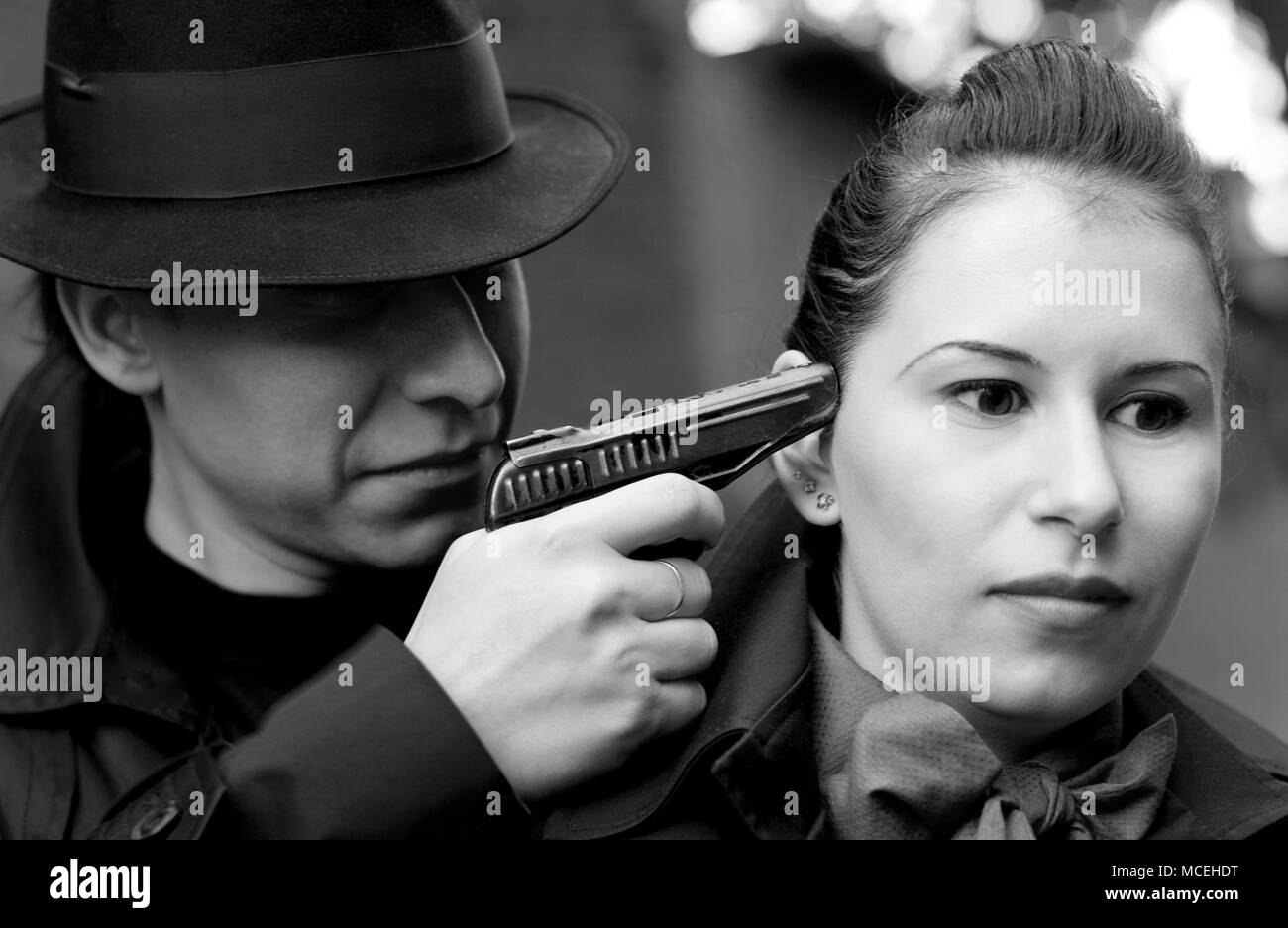 Ritratto monocromatica dell'uomo minaccia la donna con una pistola Foto Stock