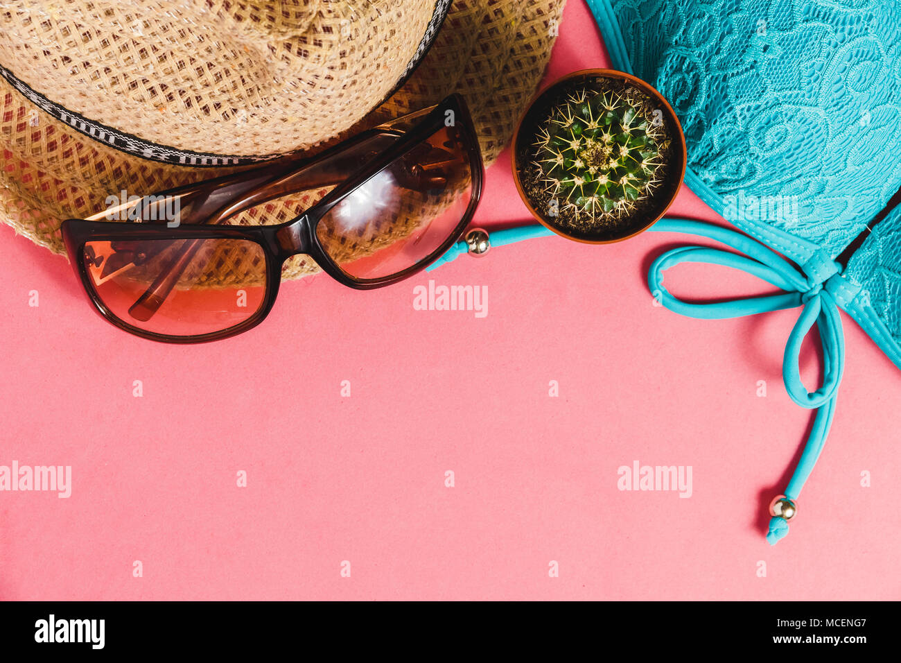 Costume da bagno, cappello, occhiali da sole, Cactus su sfondo rosa. Vista dall'alto concetto di viaggio con Copyspace Foto Stock
