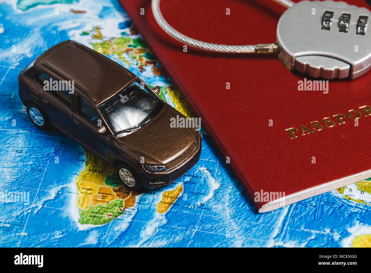Il blocco di codice sul passaporto rosso, giocattolo auto sulla mappa del mondo sullo sfondo. Concept-Ban su viaggi, mancanza di Visa Foto Stock