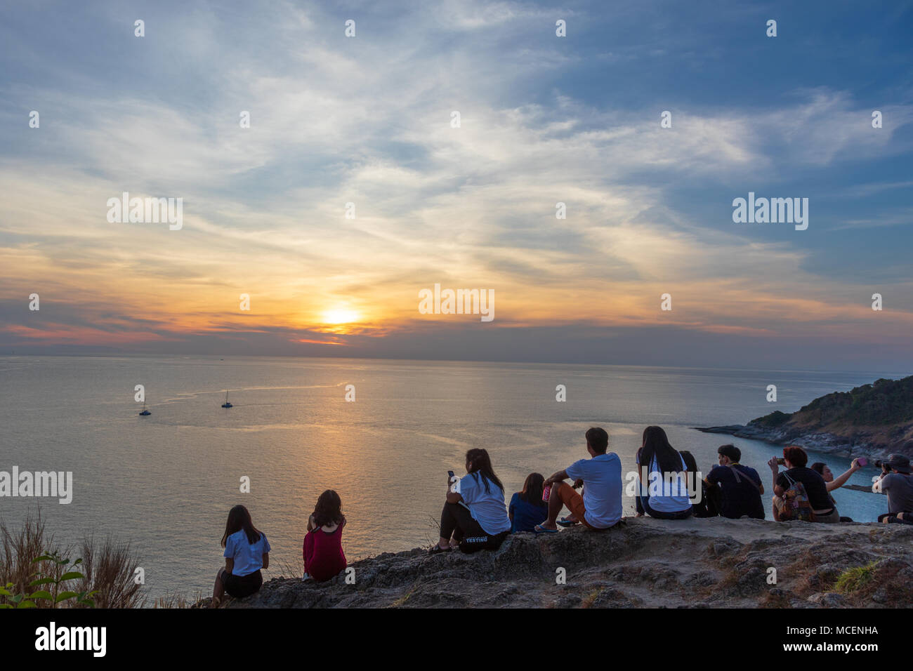 La gente seduta sulla cima di una collina in Phuket guardando il tramonto. Foto Stock