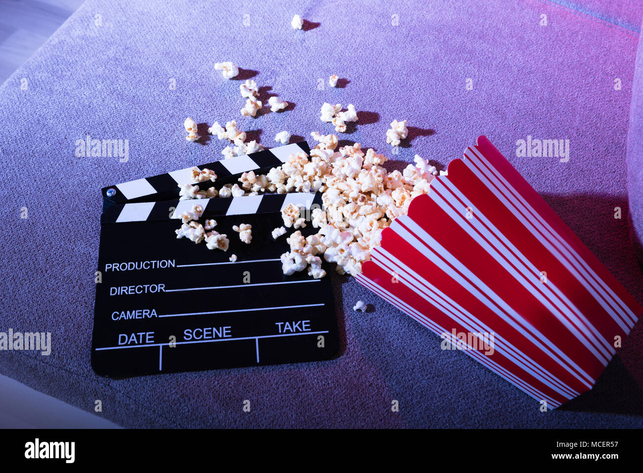 Vista in elevazione della fuoriuscita di popcorn e Clapperboard sul lettino a notte Foto Stock