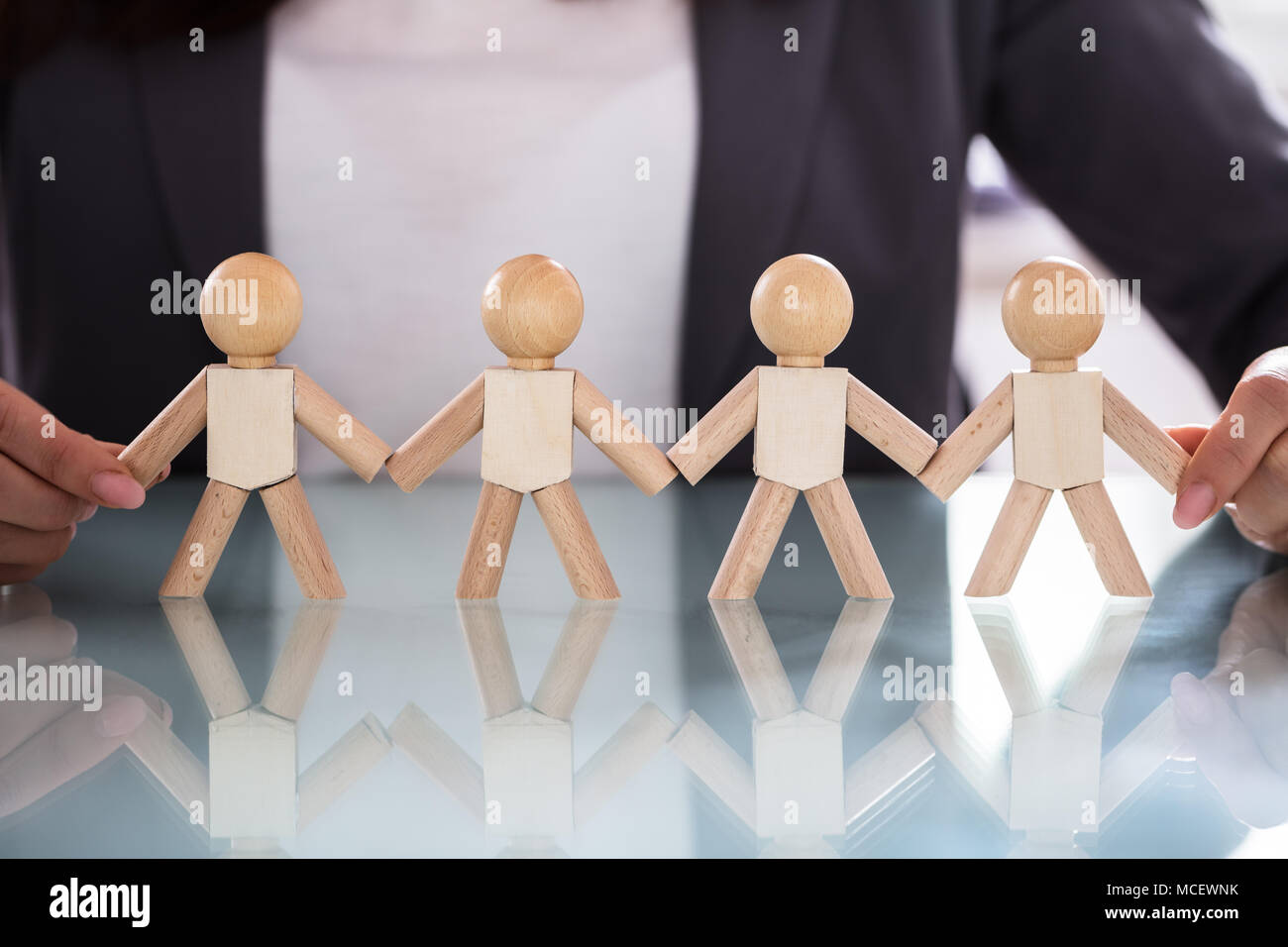 Imprenditrice azienda figura in legno la mano disposti in una fila sulla scrivania in ufficio Foto Stock