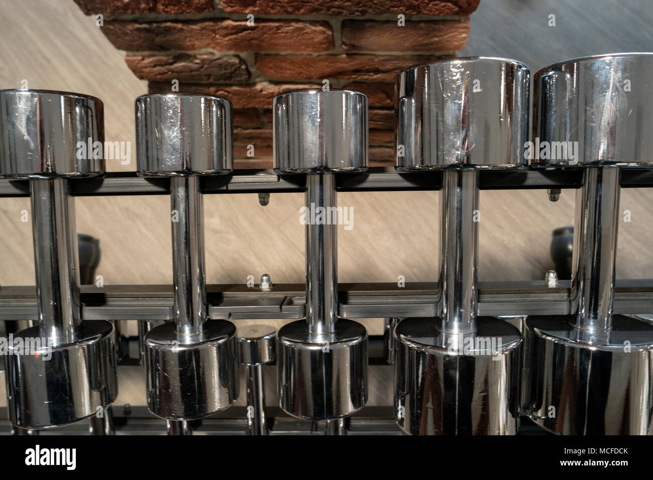 Righe di metallo manubri su rack in palestra sopra Visualizza Marrone Vintage nei toni del colore dell'immagine. Foto Stock