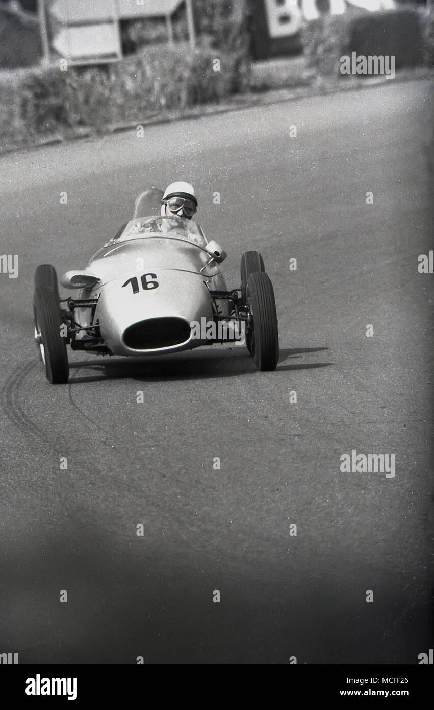 Anni sessanta, storico di una monoposto, aprire ruote auto racing essendo guidato attorno a una pista da corsa. Foto Stock