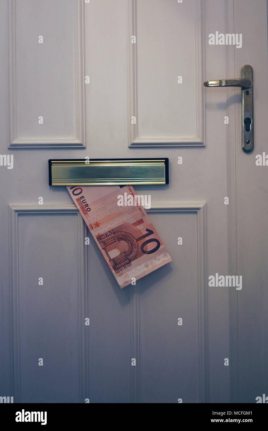 Il denaro facile - una grande dieci banconota in euro erogato attraverso una porta anteriore letterbox Foto Stock