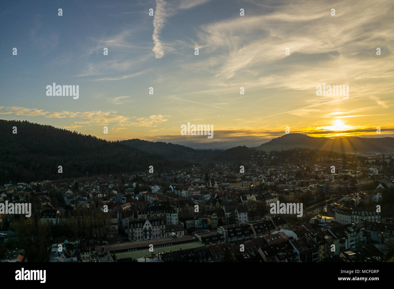 Germania, caldo arancione tramonto umore oltre le case di città di Freiburg im Breisgau dal di sopra Foto Stock