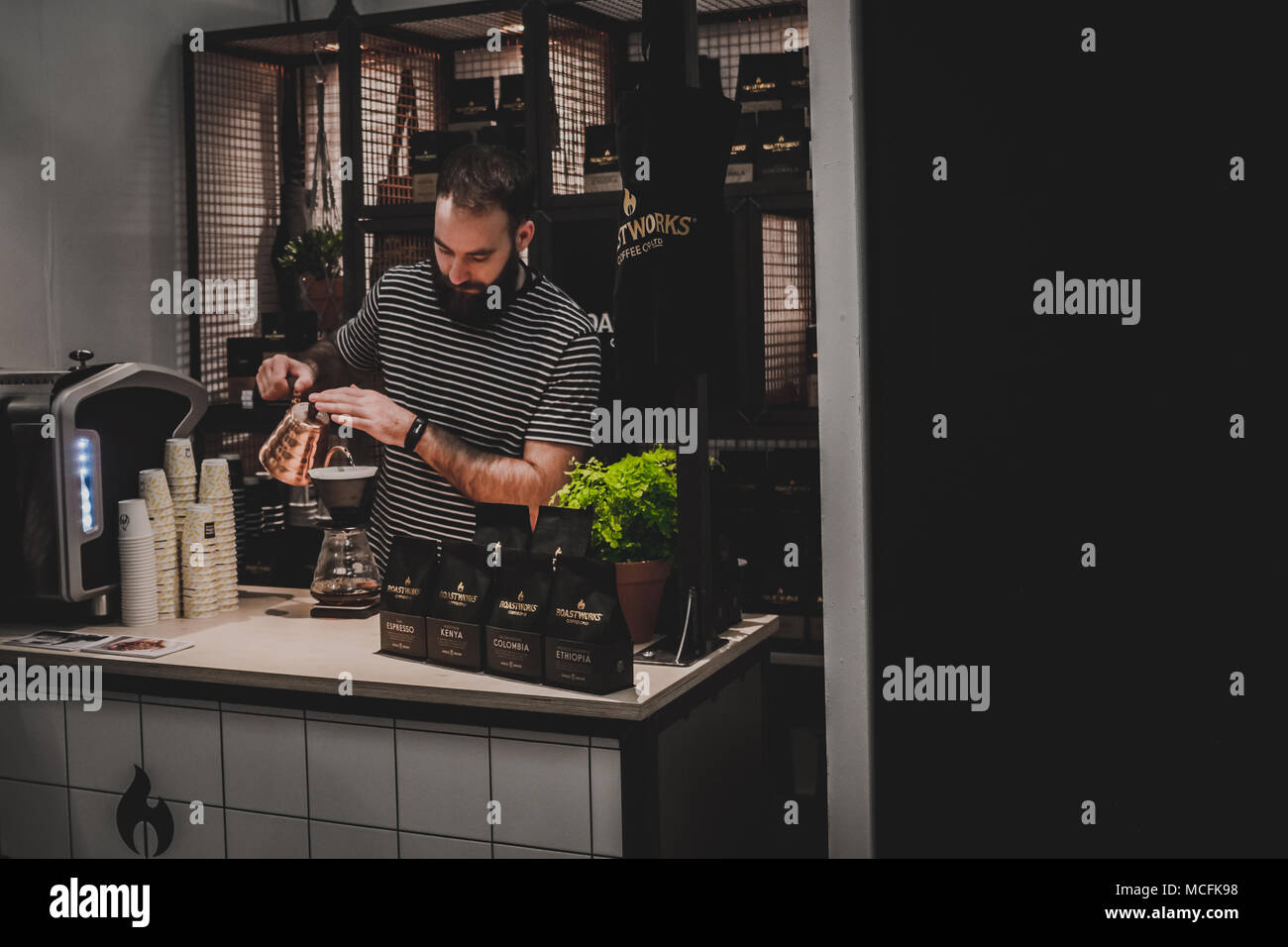 Roastworks lavoratore presso la sua stalla versando il caffè al London Coffee Festival - Aprile 2018 Foto Stock